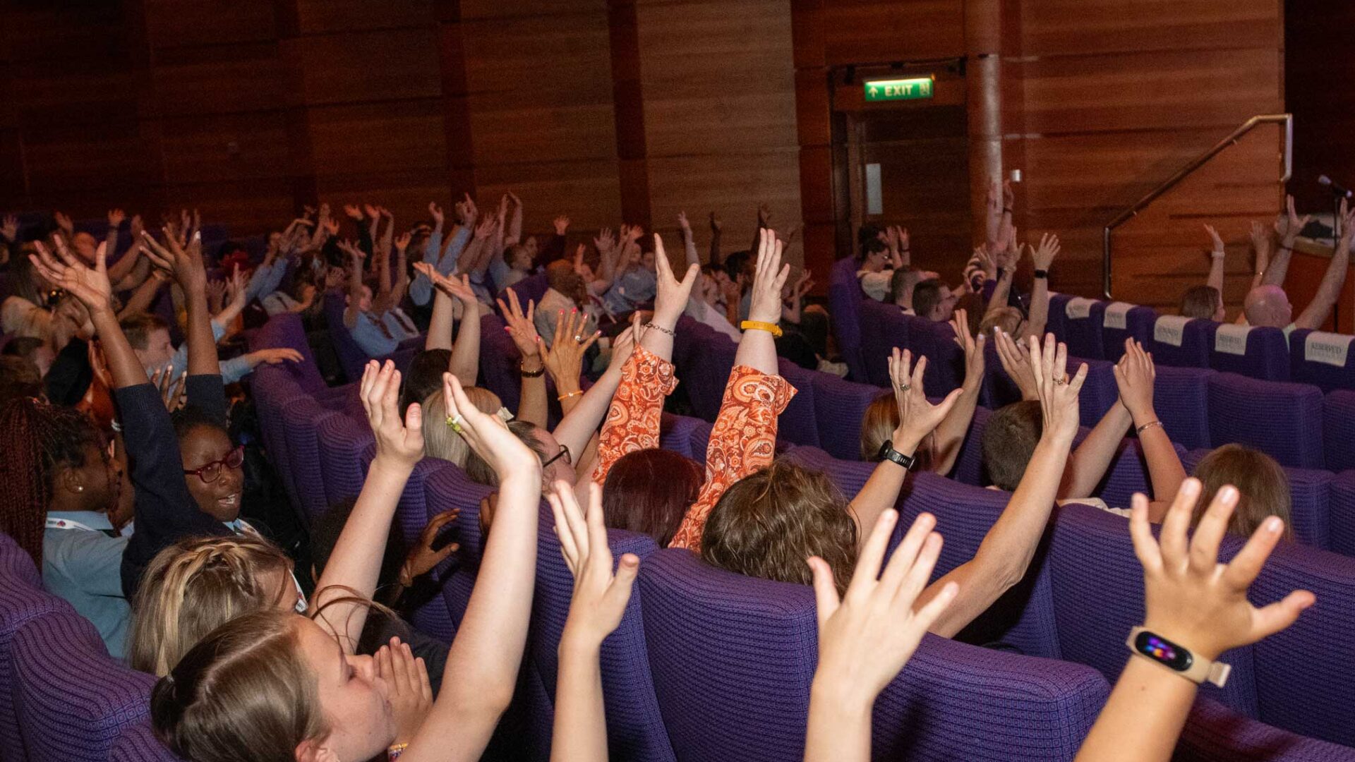 a large group of young people putting their hands up