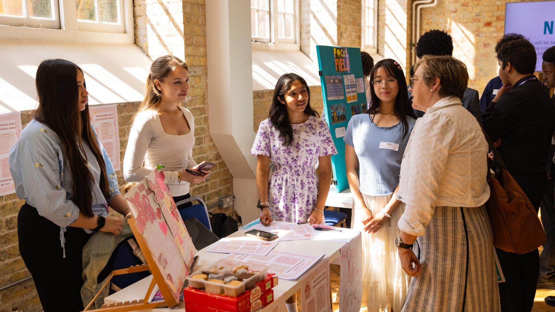 Young people speaking to a guest about their social enterprise