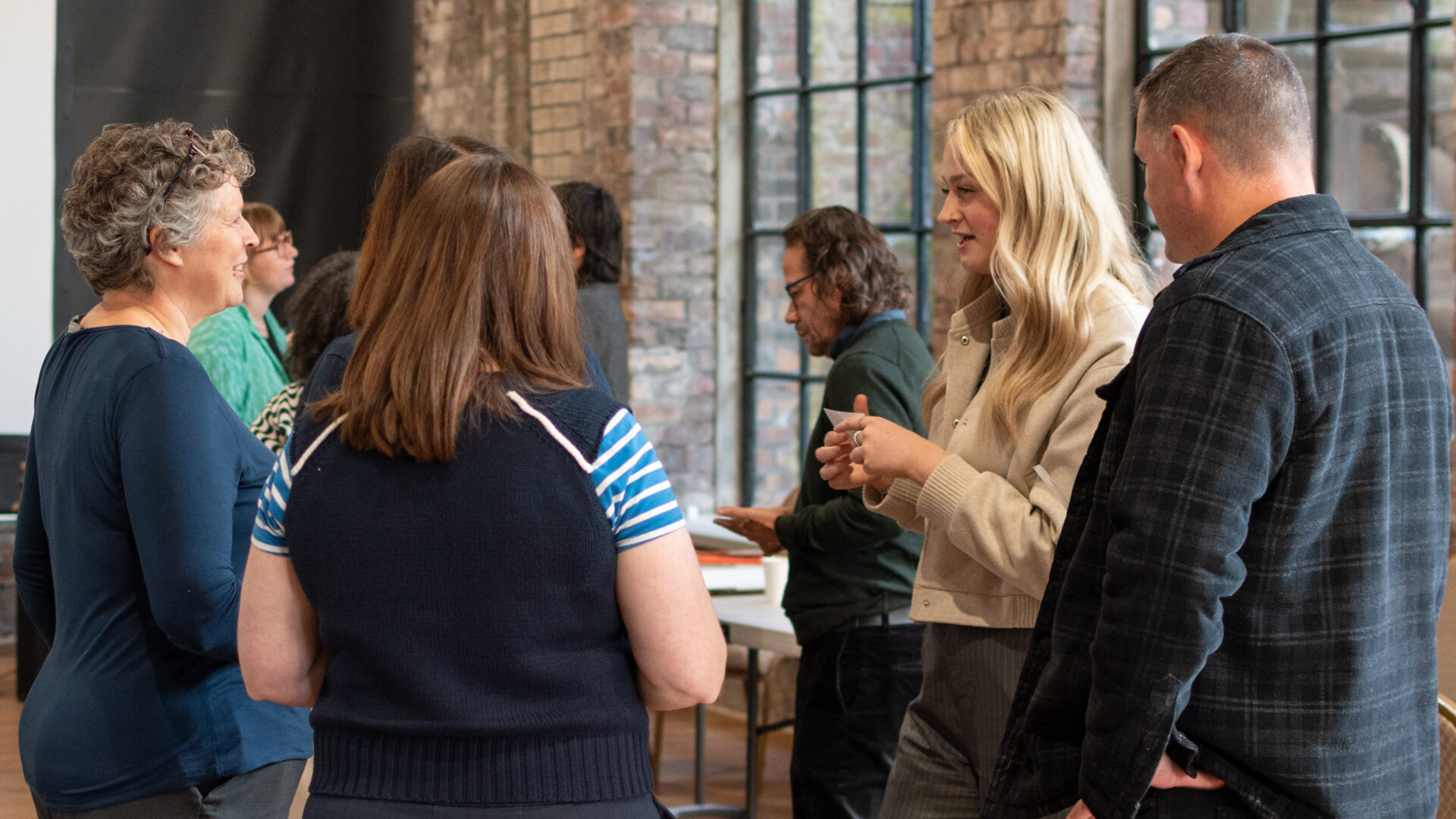 Group of people standing in circle chatting