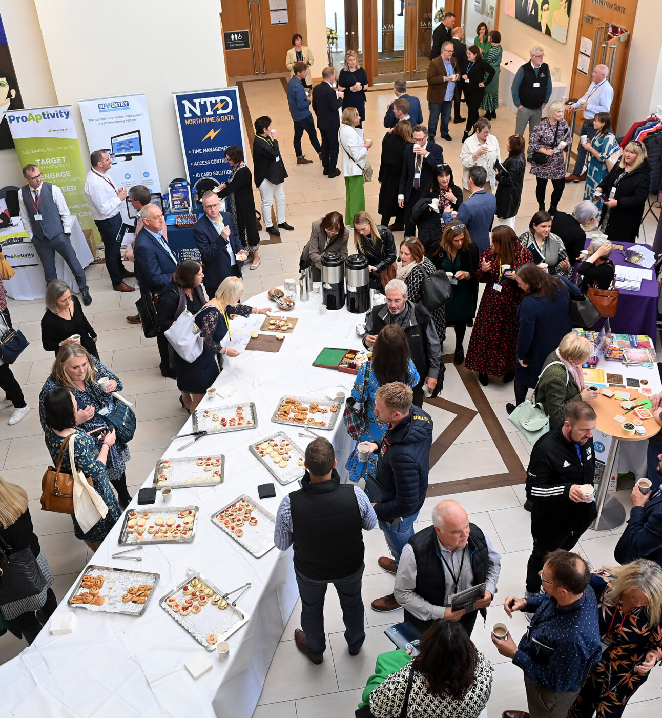 Participants talking and mingling in a large room photographed from above