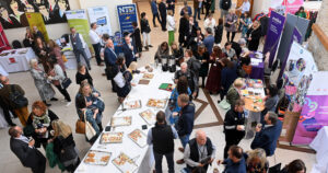 Participants talking and mingling in a large room photographed from above
